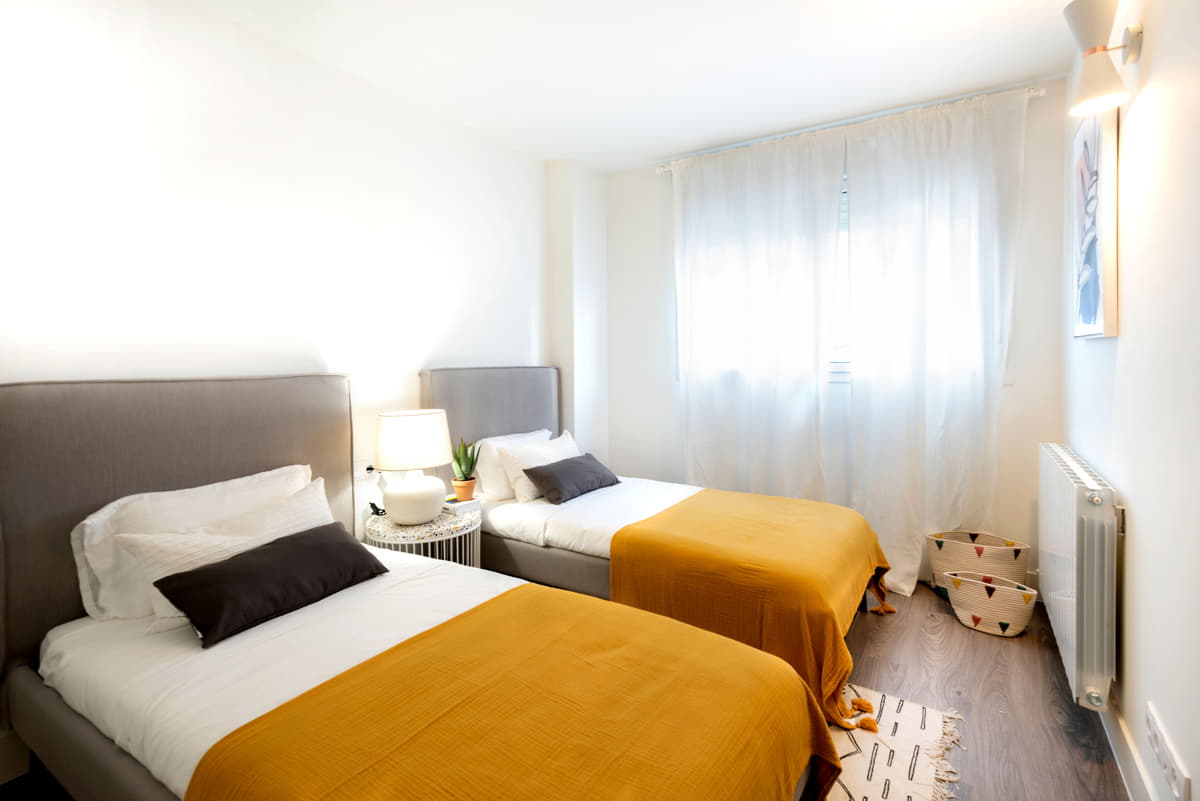 Dormitorio secundario con dos camas individuales en Essència de Sabadell