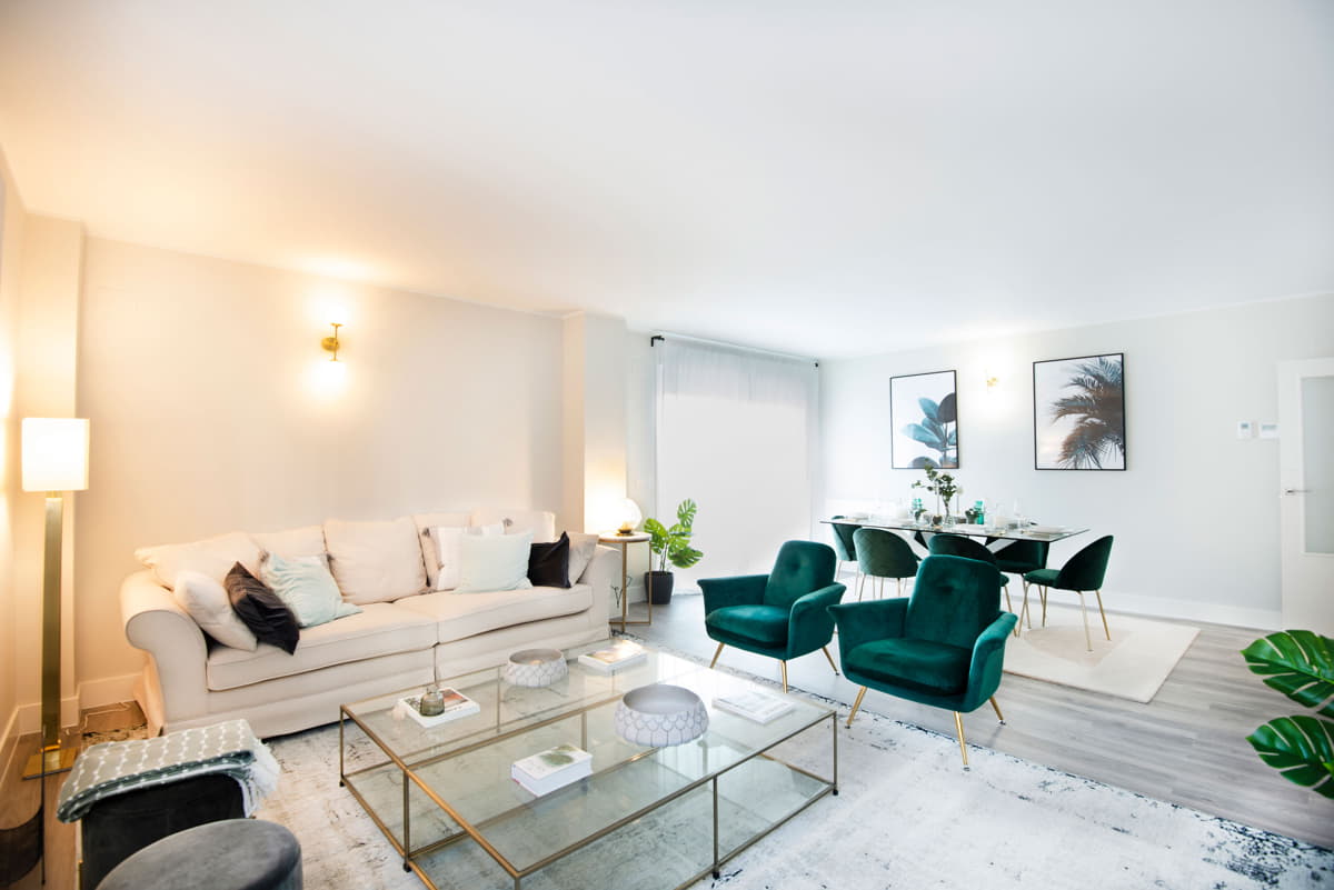 Salón con sofá, mesa auxiliar y butacas independientes de los pisos nuevos en Sabadell