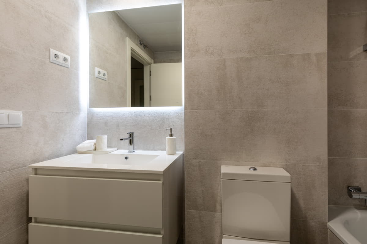 Baño principal con espejo iluminado en Portablanca